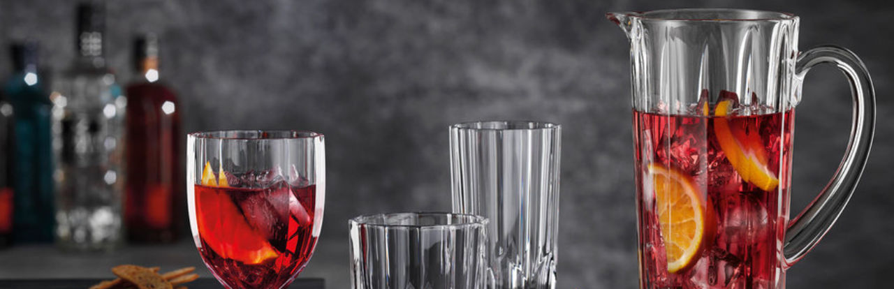 Gläser und Krug mit rotem Drink